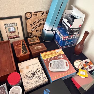 Sale Photo Thumbnail #105: Collection of tabletop decor and collectibles including decorative wooden boxes, an Ouija board, a vintage Micro Hot Plate boxed set, a Shalimar perfume box, and various home accents.
