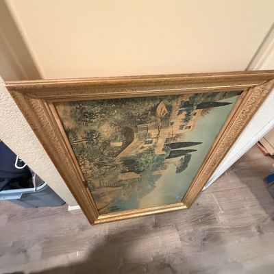Sale Photo Thumbnail #75: Large vintage framed landscape print depicting a Mediterranean villa, housed in an ornate carved gold-tone wooden frame.