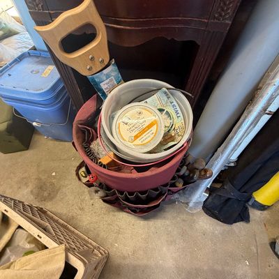 Sale Photo Thumbnail #211: Canvas tool caddy bucket organizer filled with assorted hand tools, plastic containers, and a hand saw, positioned next to a dark wood cabinet.