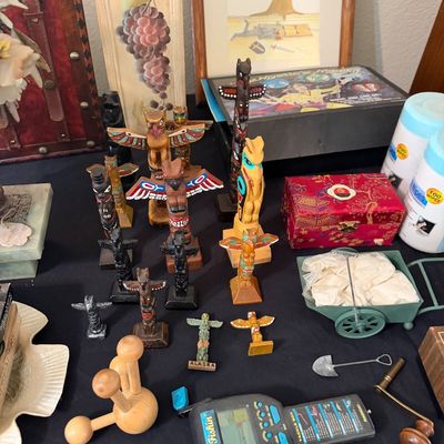 Sale Photo Thumbnail #159: Collection of souvenir miniature totem poles and decorative items, including an electronic handheld Bass Fishin' game, a red silk fabric box, and a wooden massage tool.