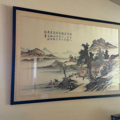 Sale Photo Thumbnail #140: Large framed traditional Chinese landscape painting featuring mountains, a river, figures, and calligraphy artwork in a simple dark wooden frame.
