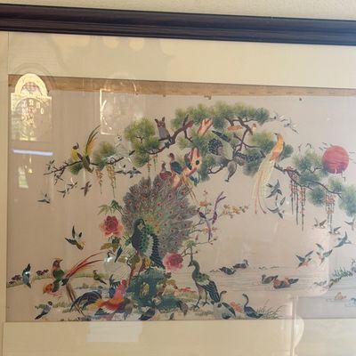 Sale Photo Thumbnail #38: Large framed vintage silk embroidery artwork depicting 100 birds among pine trees, flowers, and a red sun, housed in a dark wood frame with matting.