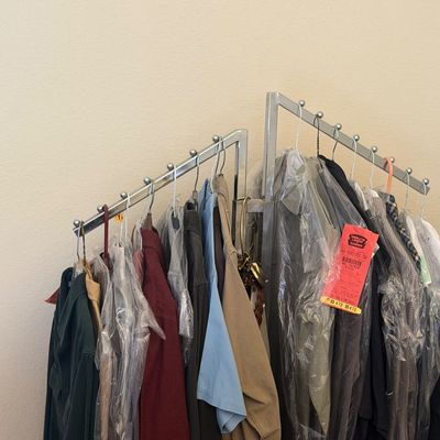 Sale Photo Thumbnail #302: Selection of men's clothing on a chrome multi-arm garment rack, including dry-cleaned shirts and jackets.
