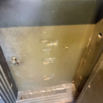 Sale Photo Thumbnail #204: Interior view of an antique metal safe featuring an inner locked compartment door with original key.