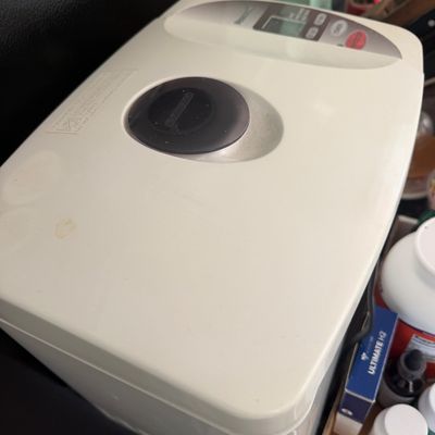 Sale Photo Thumbnail #17: Off-white automatic bread maker featuring a digital display, viewing window, and top control panel.