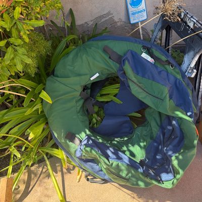 Sale Photo Thumbnail #59: Inflatable float tube in green and navy blue nylon, featuring zippered storage pockets and adjustable straps for fishing.