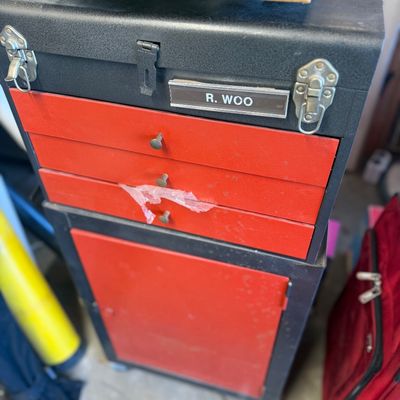 Sale Photo Thumbnail #248: Black and red metal tool chest combo featuring a top chest with three drawers and a bottom cabinet with a single door.