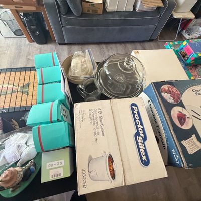 Sale Photo Thumbnail #93: Collection of kitchen items and small appliances, including a boxed Proctor Silex 4-quart slow cooker, a Rival chocolate fountain in box, a clear glass cake dome, and stacked turquoise boxes.