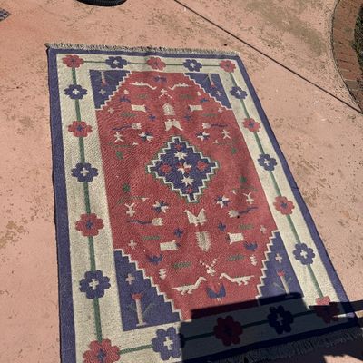 Sale Photo Thumbnail #297: Handwoven flat-weave Kilim area rug featuring geometric and animal motifs in red, blue, green, and cream hues with fringed ends.