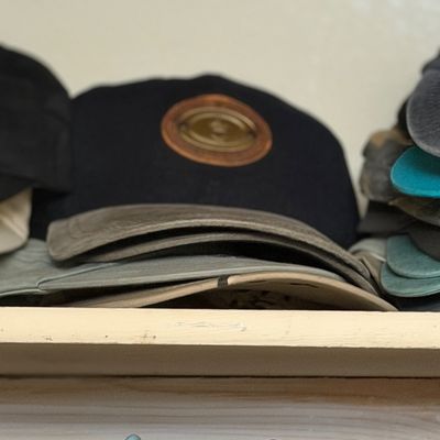 Sale Photo Thumbnail #174: Collection of assorted modern baseball caps and hats stacked on a closet shelf.