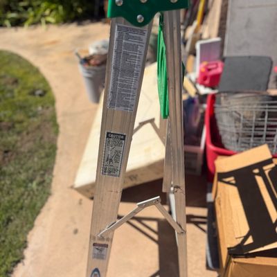 Sale Photo Thumbnail #257: Werner aluminum step ladder with a green top tray, showing light use and wear.