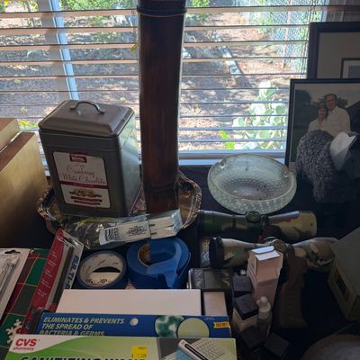 Sale Photo Thumbnail #155: Collection of tabletop items including a CVS sanitizing wand, Knott's Berry Farm cookie tin, glass ashtray, and camouflage rifle scopes.