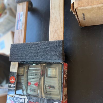 Sale Photo Thumbnail #251: Bandit Buster motion sensor security system in original packaging, set alongside a carpeted wooden furniture dolly.