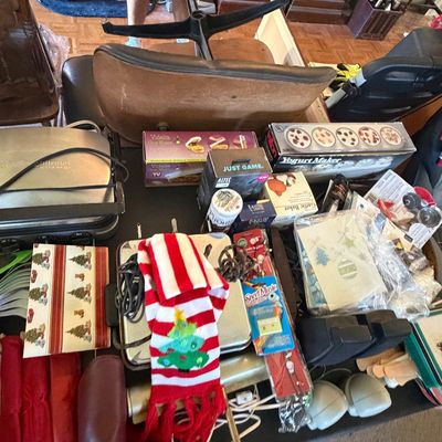 Sale Photo Thumbnail #126: Table packed with an assortment of vintage and modern household items, including small kitchen appliances, Christmas decorations, stationery, and boxed goods.