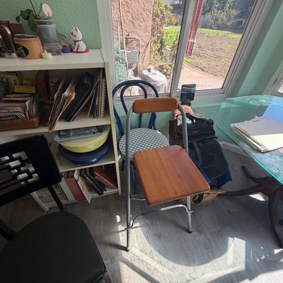 Sale Photo Thumbnail #83: Foldable step stool chair with wooden seat and backrest alongside a blue Thonet-style chair, surrounded by office and household furniture.