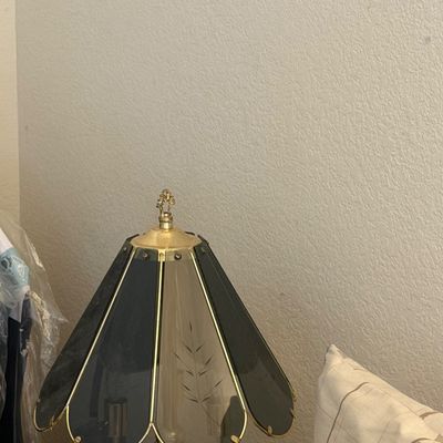 Sale Photo Thumbnail #301: Vintage touch lamp featuring a polished brass frame with smoked and etched glass panel shade segments, circa late 20th century.