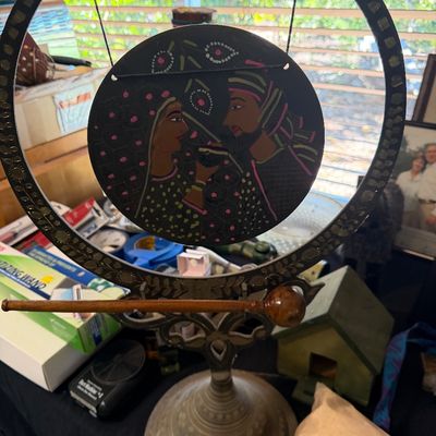 Sale Photo Thumbnail #156: Vintage Indian brass tabletop gong featuring a central hand-painted disc depicting a couple, complete with matching wooden striker.