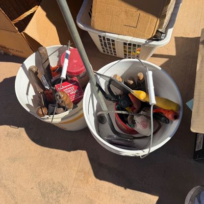 Sale Photo Thumbnail #258: Two white plastic buckets filled with an assortment of hand tools, hardware, and plumbing supplies.