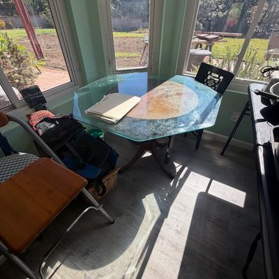 Sale Photo Thumbnail #84: Octagonal bevel-edged glass top dining table with a wooden pedestal base set in a sunlit room.