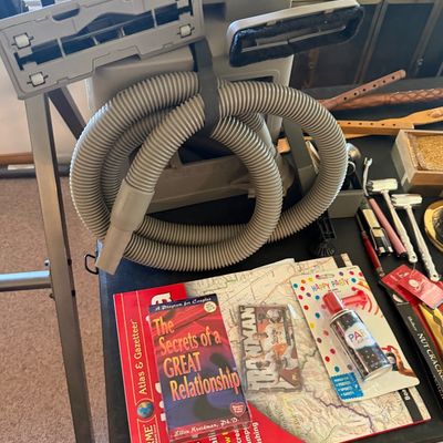 Sale Photo Thumbnail #139: Selection of household items including a canister vacuum with attached hose and floor heads, various books, maps, and novelties.