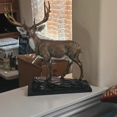 Sale Photo Thumbnail #105: Detailed statue of a majestic stag with large antlers standing on a rocky base attached to a black plinth.