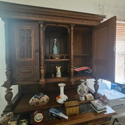 Sale Photo Thumbnail #96: Vintage dark wood carved hutch cabinet with open display shelves and small porcelain figurines and decor items inside.
