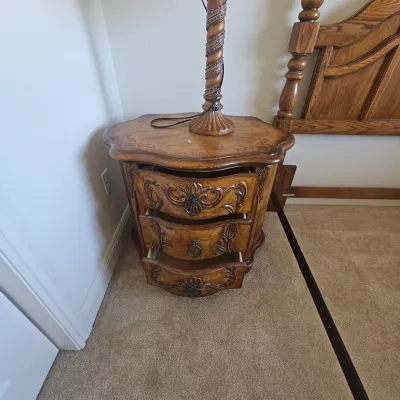 Sale Photo Thumbnail #78: Ornate traditional three-drawer nightstand with carved floral accents, metal ring pulls, and a scalloped top.