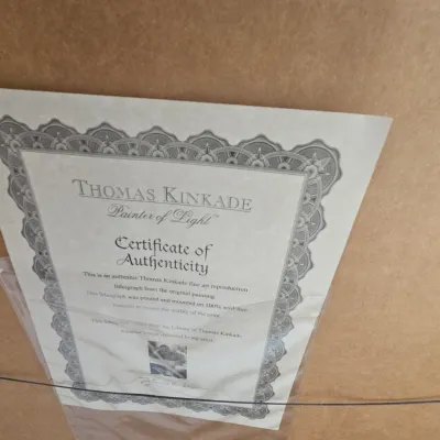 Sale Photo Thumbnail #82: Thomas Kinkade Certificate of Authenticity attached to the back of a framed artwork.