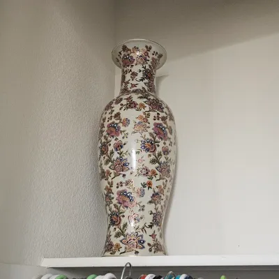 Sale Photo Thumbnail #88: Tall Asian-style porcelain floor vase featuring intricate hand-painted floral motifs with gilded accents.