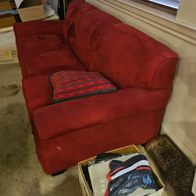 Sale Photo Thumbnail #41: Red microfiber or faux-suede three-cushion sofa featuring rounded arms, accompanied by a striped throw pillow.