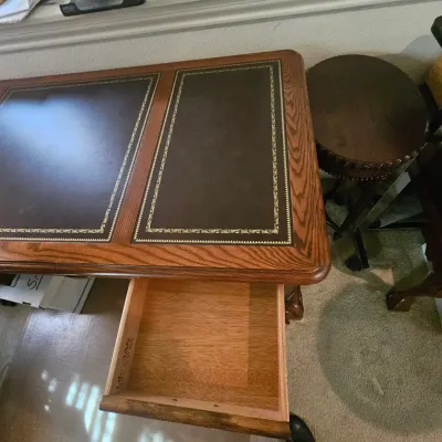 Sale Photo Thumbnail #21: Vintage Hekman executive desk featuring a oak frame with a gold-tooled leather inset top and open side drawer.