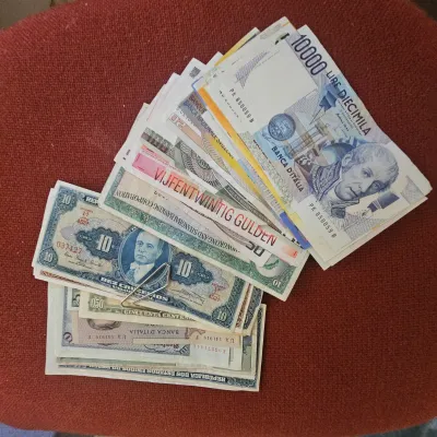 Sale Photo Thumbnail #44: Collection of assorted vintage international paper currency, including Italian lira, Dutch gulden, and Brazilian cruzeiros.