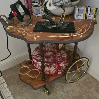 Sale Photo Thumbnail #15: Vintage Italian style marquetry tea cart with brass accents and large spoked wheels, holding decor and supplies.