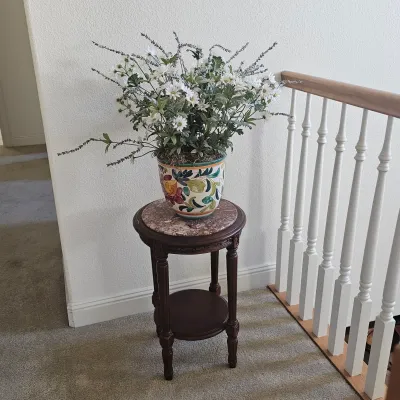 Sale Photo Thumbnail #61: Traditional dark wood plant stand featuring a pink-and-grey marble top, paired with a hand-painted ceramic planter holding faux white daisy floral arrangements.