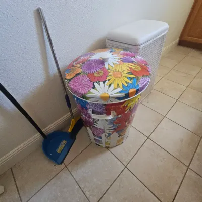 Sale Photo Thumbnail #83: Vintage retro floral print metal hamper alongside a white wicker laundry basket and cleaning tools.