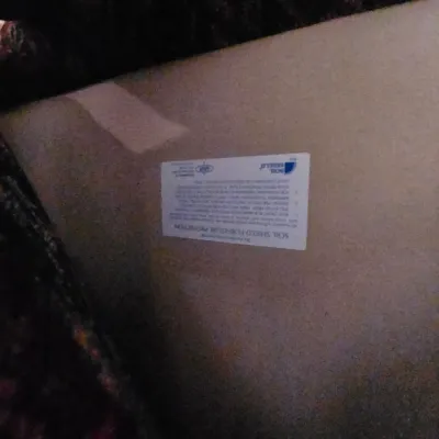 Sale Photo Thumbnail #103: Underside of an upholstered furniture piece featuring an upside-down Soil Shield Furniture Protection manufacturer label.