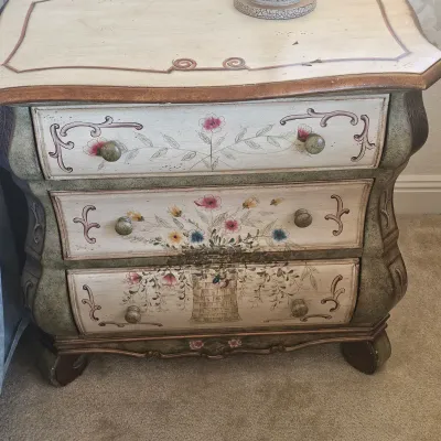 Sale Photo Thumbnail #72: French Country hand-painted three-drawer nightstand featuring floral motifs, a distressed cream and green finish, and curved side legs.