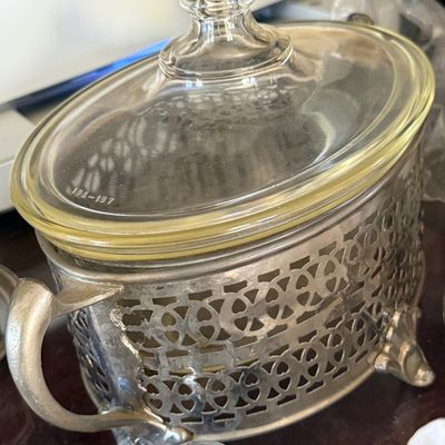 Sale Photo Thumbnail #56: Vintage glass casserole insert with matching lid, housed in a reticulated silver-plated holder with handles and ornate feet.