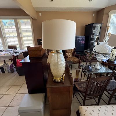 Sale Photo Thumbnail #67: Living room filled with household goods including a modern table lamp with a white drum shade, traditional wooden furniture, and various lamps.