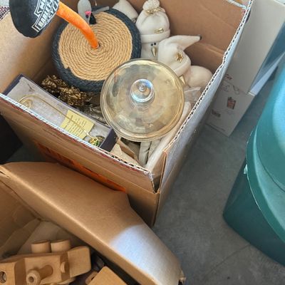 Sale Photo Thumbnail #89: Cardboard box containing a variety of holiday decorations, novelty items including a Harley-Davidson branded object, and glass ornaments, alongside another box of wooden toys.