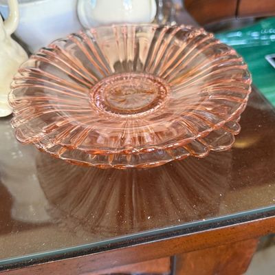 Sale Photo Thumbnail #80: Stack of vintage pink depression glass saucers featuring a ribbed starburst design.