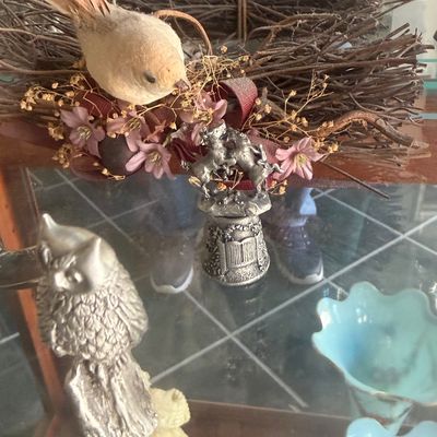 Sale Photo Thumbnail #143: Collection of decorative collectibles, including a twig bird nest wreath, small silver-toned Pewter-style figurines, and blue ruffled glass dishes.