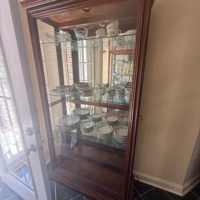 Sale Photo Thumbnail #7: Traditional wood curio cabinet with glass side panels, mirrored back, interior lighting, and several shelves displayed with a set of fine china.