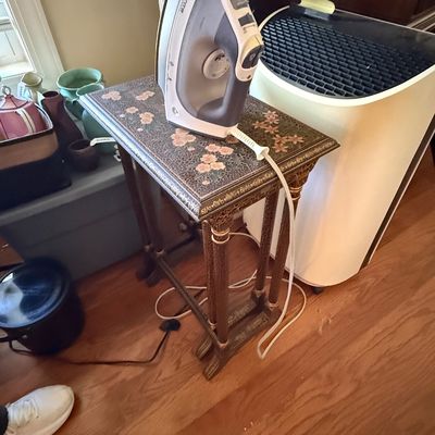 Sale Photo Thumbnail #42: A modern Rowenta steam iron resting on an ornate floral-patterned side table alongside a portable air conditioner.