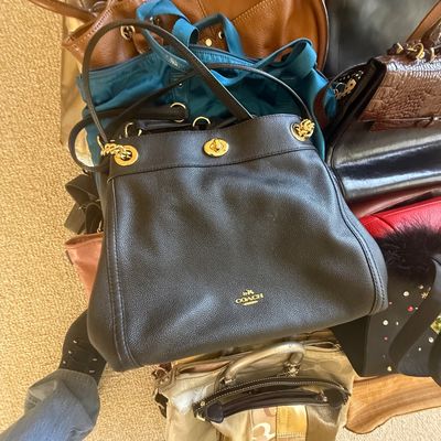Sale Photo Thumbnail #162: A collection of assorted women's handbags and totes, prominently featuring a black pebbled leather Coach shoulder bag with gold-tone hardware.