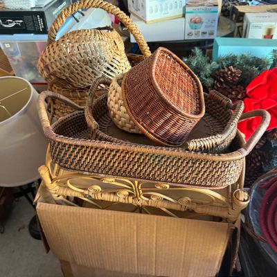 Sale Photo Thumbnail #88: Collection of woven wicker and rattan items, including decorative trays, small baskets, and a small scrollwork plant stand.
