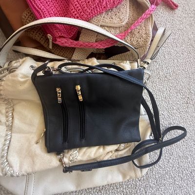 Sale Photo Thumbnail #183: Collection of women's handbags including a black leather crossbody purse with gold zipper details, a metallic off-white shoulder bag, and crocheted bags.