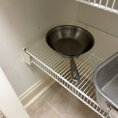 Sale Photo Thumbnail #86: Small stainless steel skillet sitting on a white wire pantry shelf.