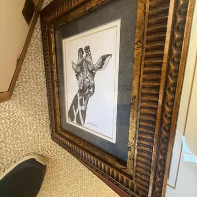 Sale Photo Thumbnail #194: Framed black-and-white sketch of a giraffe, mounted in a double mat and ornate gilded wooden frame.