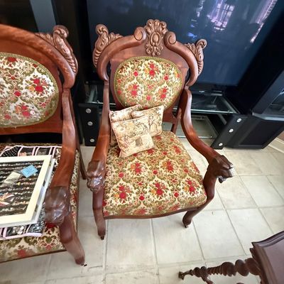 Sale Photo Thumbnail #68: Pair of ornate Victorian-style wooden armchairs with carved lion heads on the armrests and floral brocade upholstery.